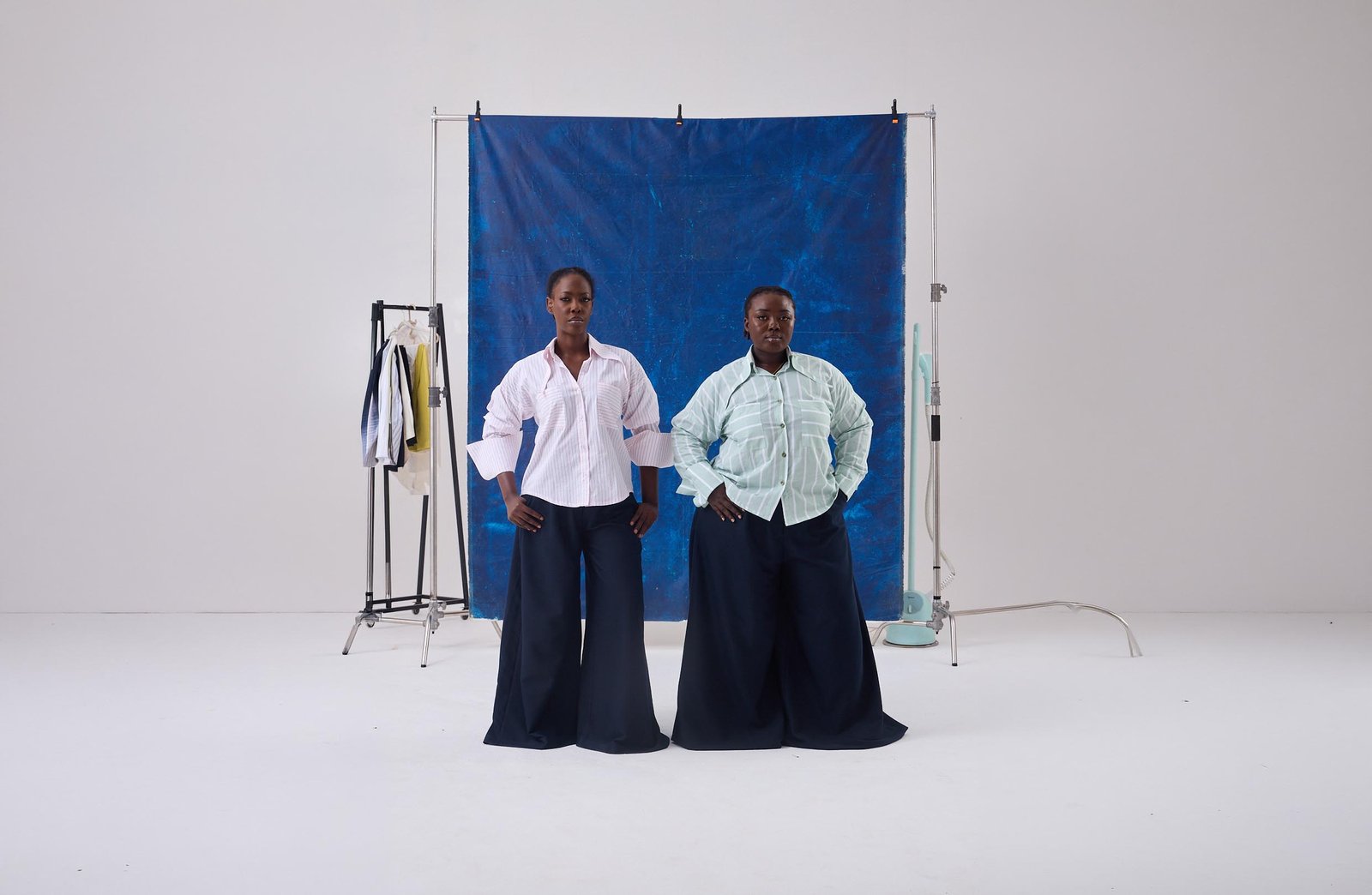 Two women in ASIWO striped shirts and wide navy trousers